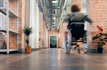 Personne en fauteuil roulant avançant dans un couloir